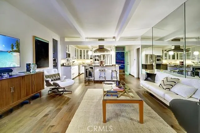 a living room with furniture kitchen view and a large window