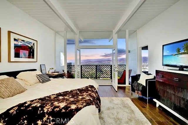 a bedroom with a bed and a flat screen tv