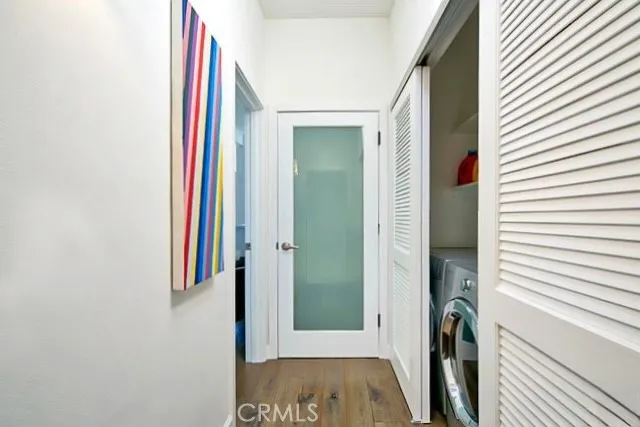 a view of hallway with bathroom and wooden floor