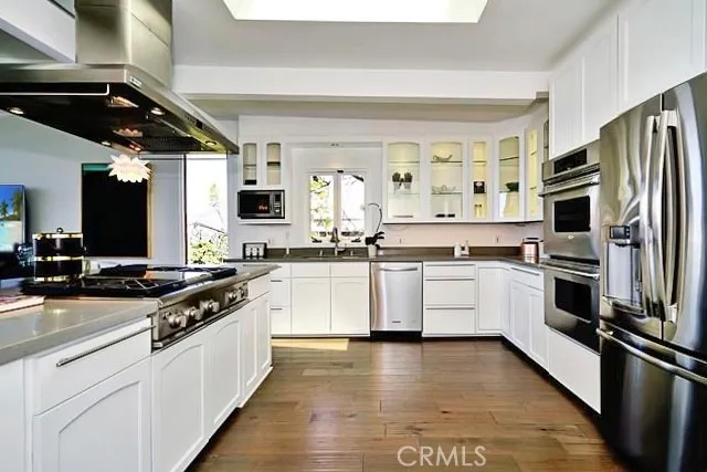 a kitchen with white cabinets and appliances