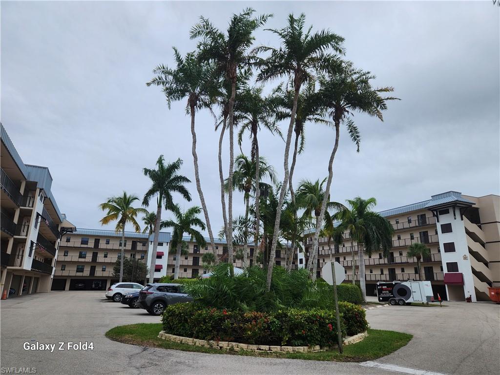 805 River Point Drive, Unit C307 Naples, FL 34102 - Photo 11 of 11 a building with palm trees in front of it