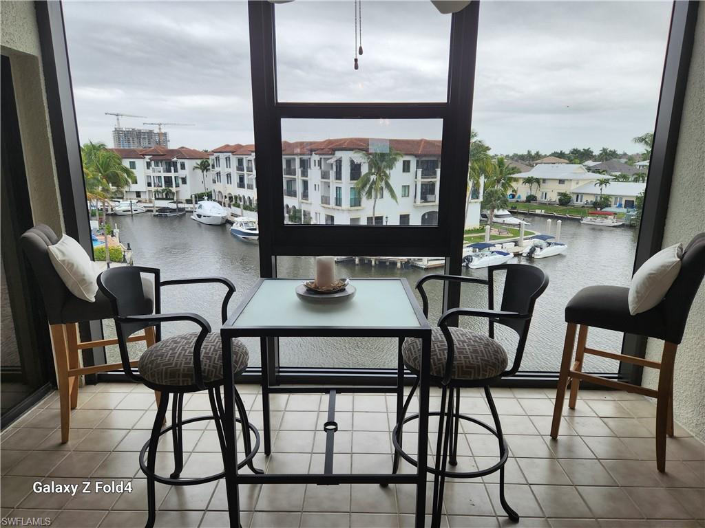 805 River Point Drive, Unit C307 Naples, FL 34102 - Photo 4 of 11 a dining room with furniture and a floor to ceiling window