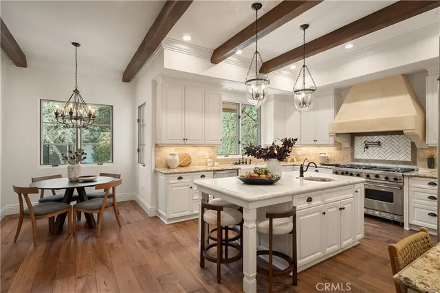 a kitchen with a stove a sink a dining table and chairs