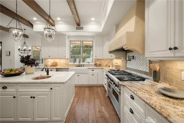 a kitchen with granite countertop a sink stove and cabinets