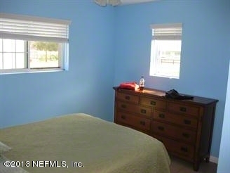 4060 South Francis Road St. Augustine, FL 32092 - Photo 23 of 25 a bed sitting in a bedroom next to a window