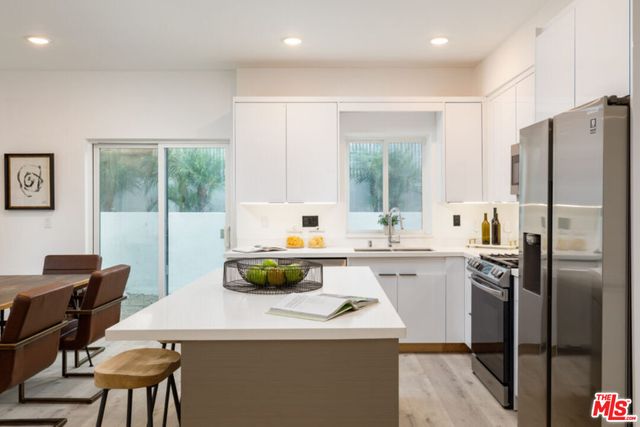a kitchen with a dining table cabinets and appliances