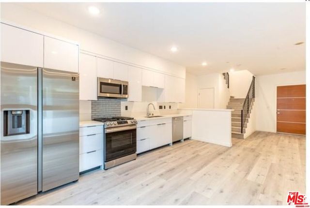 a large kitchen with cabinets and stainless steel appliances