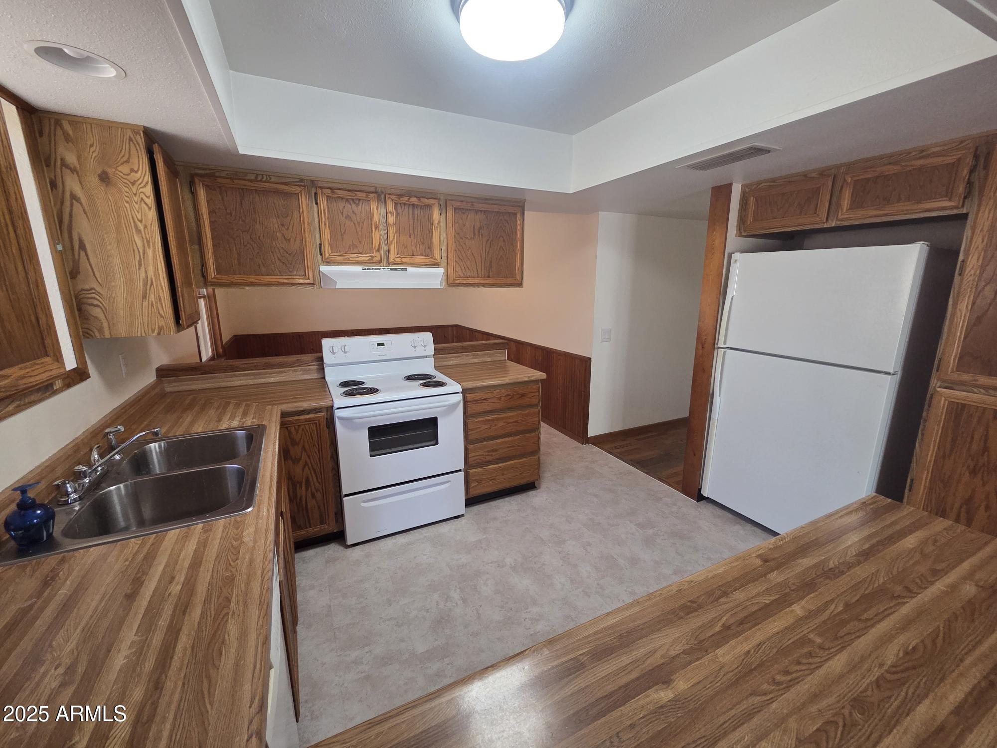 10242 East Spring Creek Road Sun Lakes, AZ 85248 - Photo 12 of 30 a kitchen with a stove a refrigerator and a sink