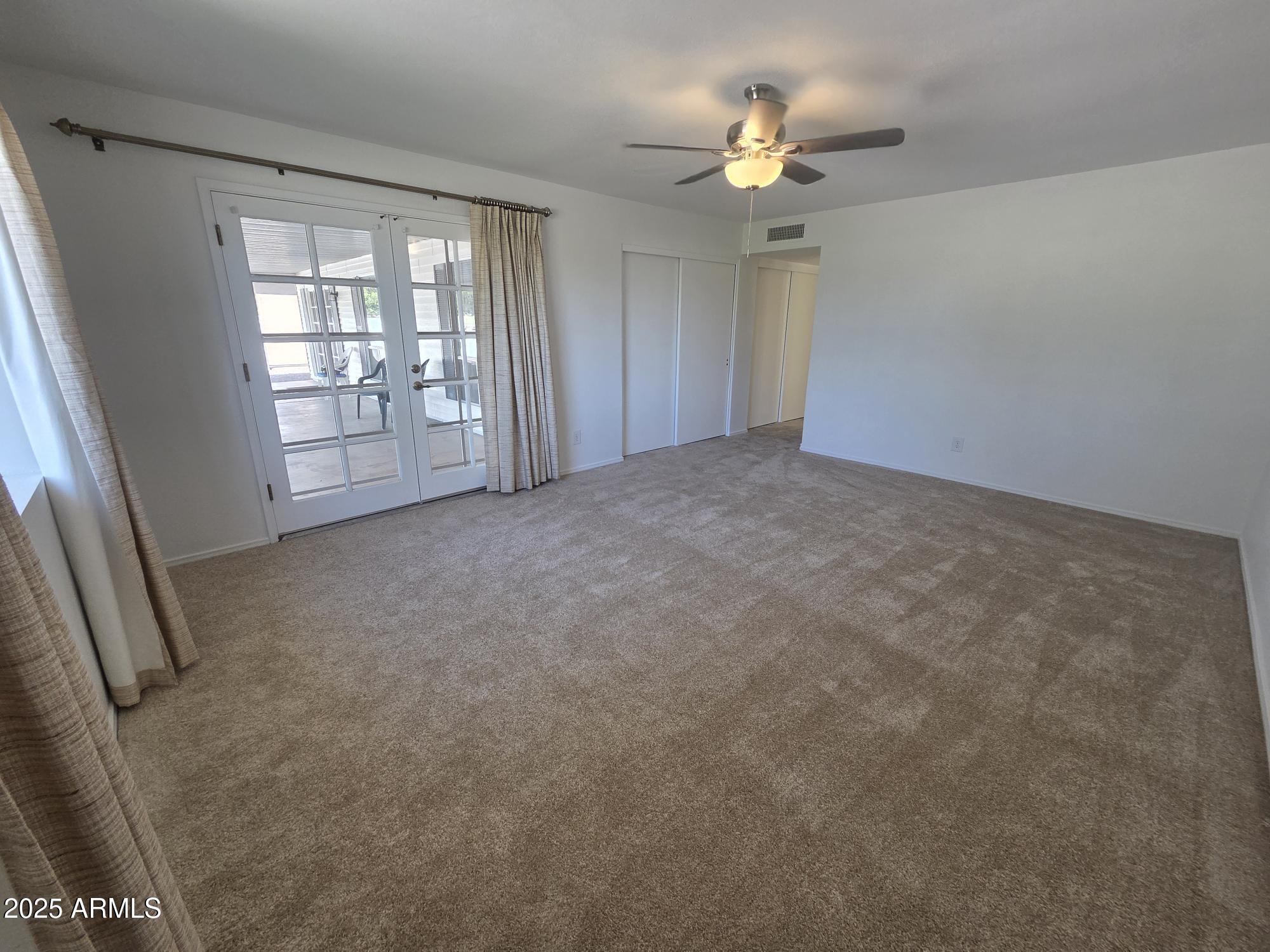 10242 East Spring Creek Road Sun Lakes, AZ 85248 - Photo 16 of 30 an empty room with chandelier fan and windows