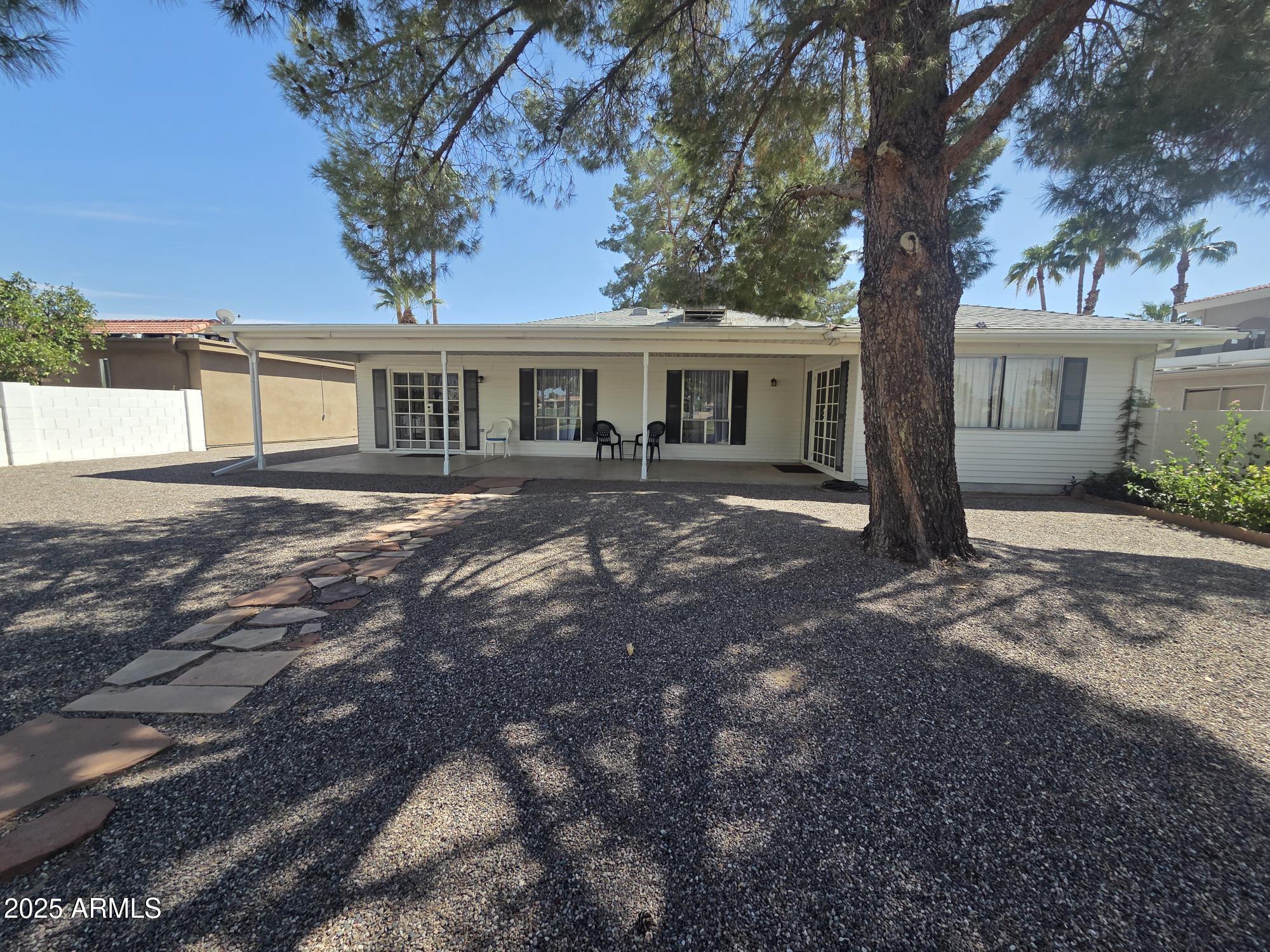 10242 East Spring Creek Road Sun Lakes, AZ 85248 - Photo 29 of 30 a front view of a house with a garden and trees