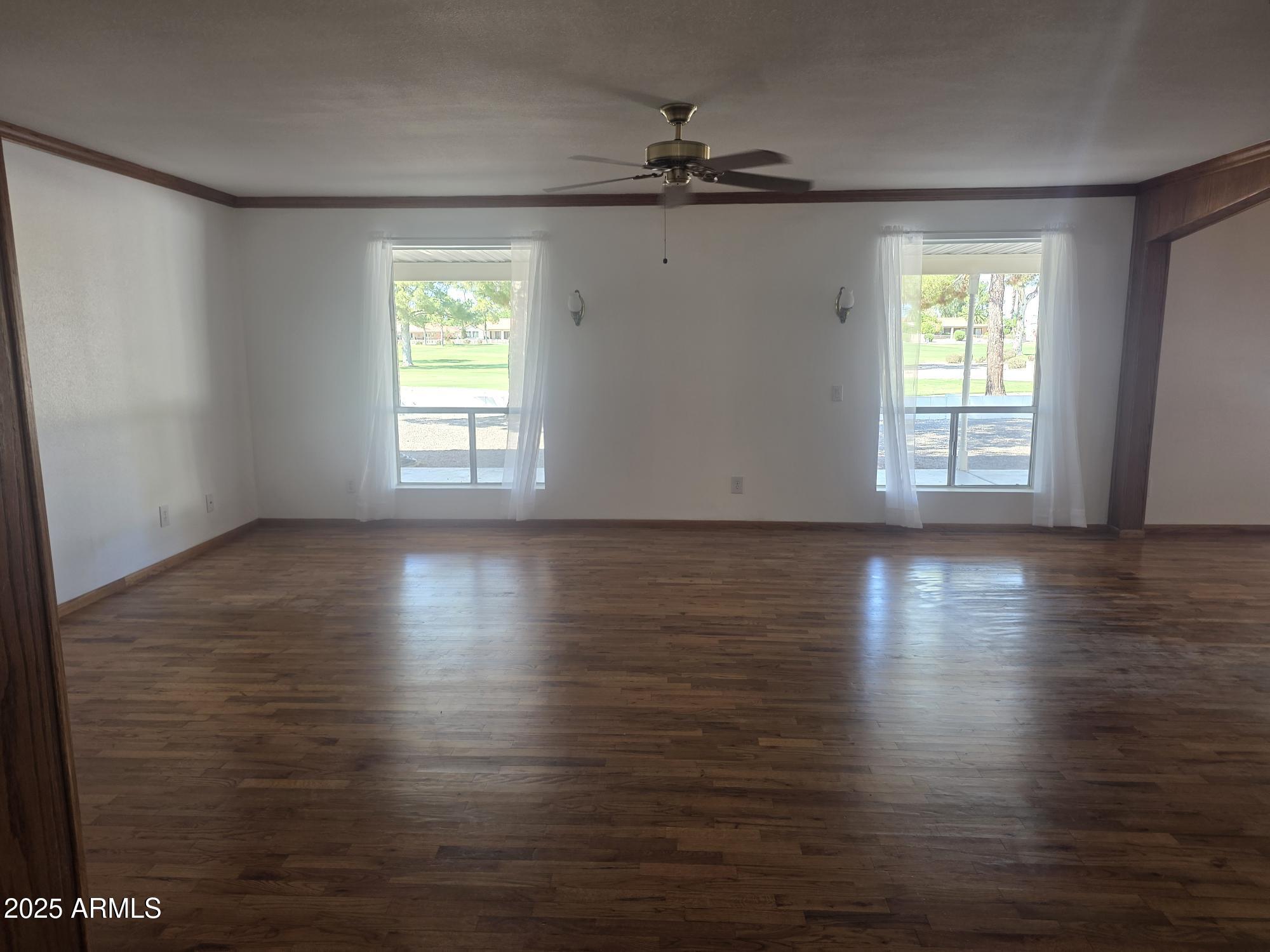 10242 East Spring Creek Road Sun Lakes, AZ 85248 - Photo 5 of 30 a view of an empty room with wooden floor and a window