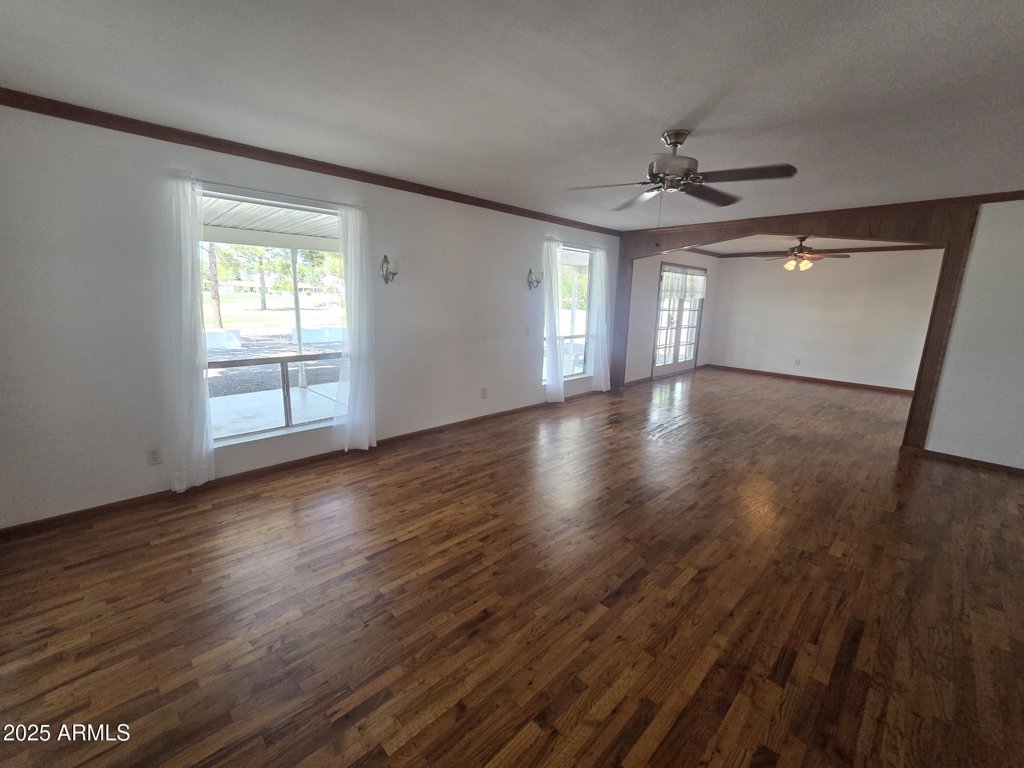 10242 East Spring Creek Road Sun Lakes, AZ 85248 - Photo 7 of 30 a view of an empty room with wooden floor and a window