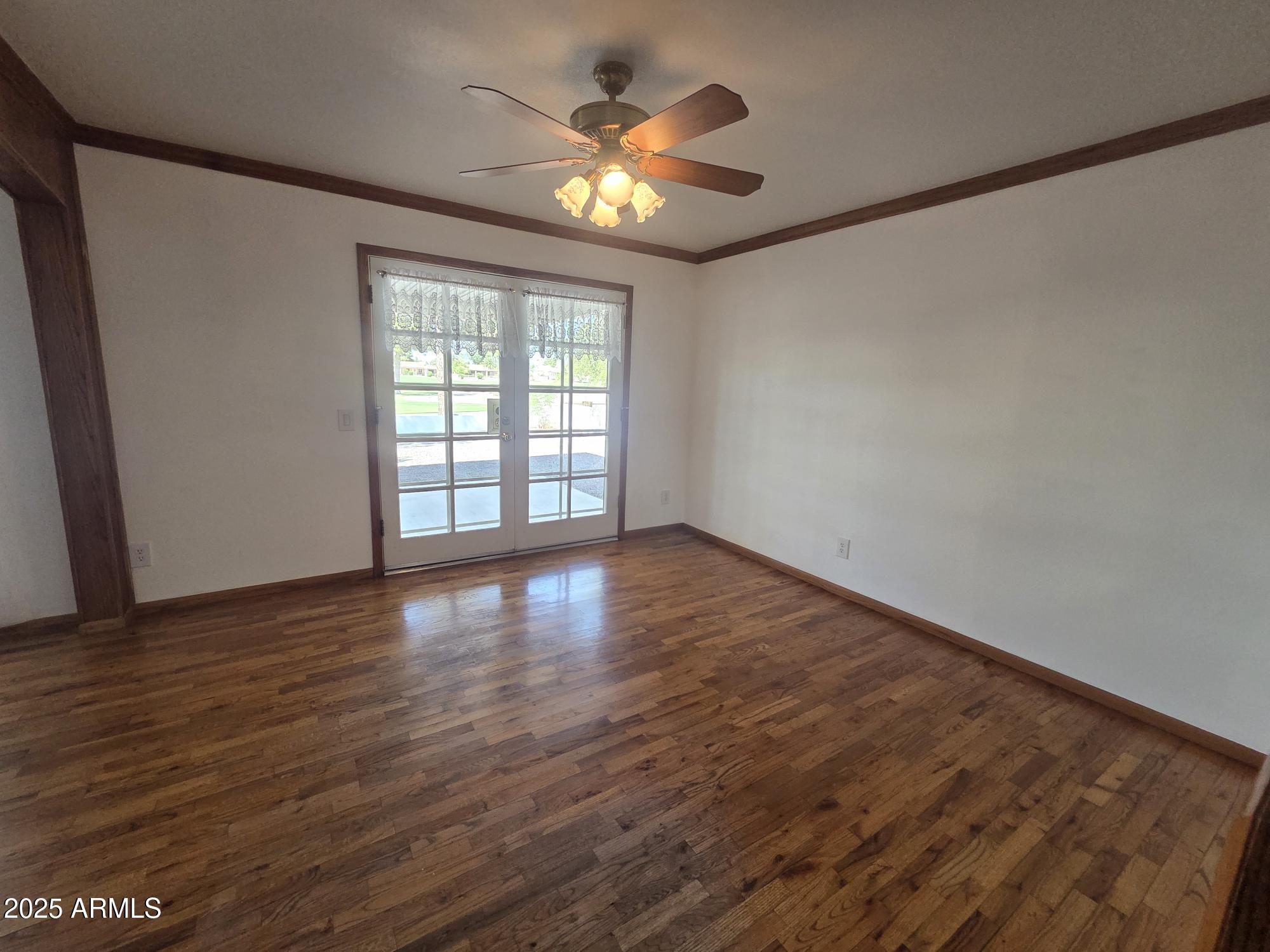 10242 East Spring Creek Road Sun Lakes, AZ 85248 - Photo 9 of 30 an empty room with wooden floor and windows