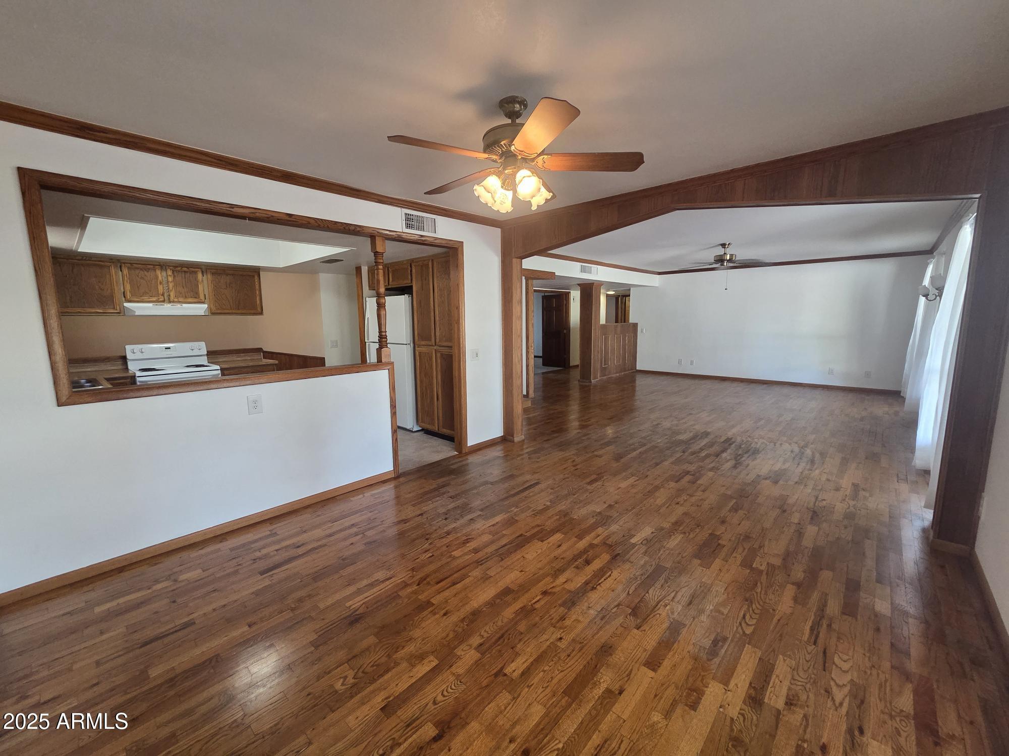 10242 East Spring Creek Road Sun Lakes, AZ 85248 - Photo 10 of 30 a view of a livingroom with wooden floor and a ceiling fan