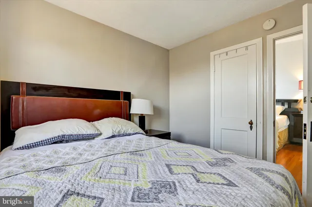 a bedroom with a bed and closet with mirror