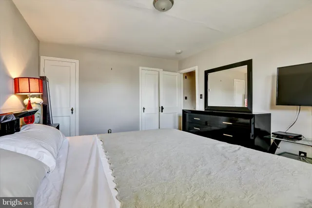a bedroom with a bed and a flat tv screen on dresser