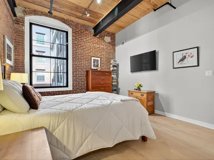 a bedroom with a bed and a flat screen tv