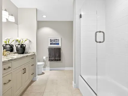 a spacious bathroom with a granite countertop sink a toilet and shower