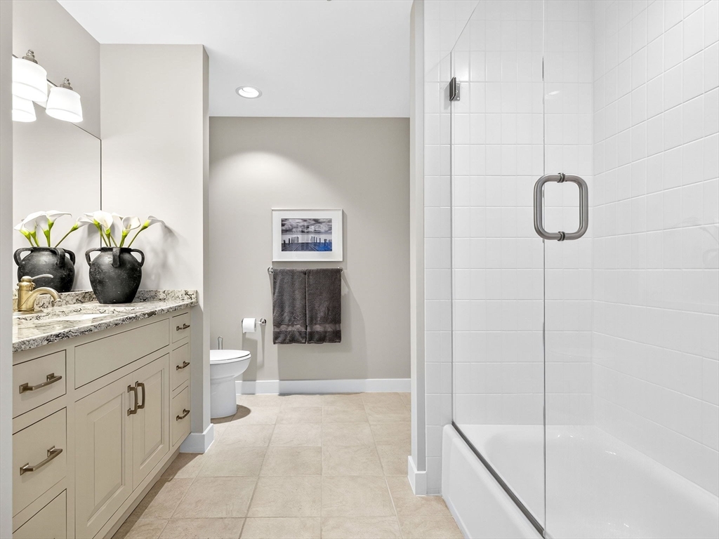 1245 Adams Street, Unit B406 Boston, MA 02124 - Photo 16 of 31 a spacious bathroom with a granite countertop sink a toilet and shower