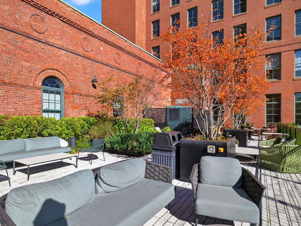 1245 Adams Street, Unit B406 Boston, MA 02124 - Photo 22 of 31 a view of a patio with couches table and chairs and potted plants