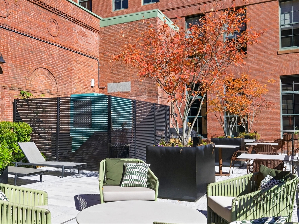 1245 Adams Street, Unit B406 Boston, MA 02124 - Photo 23 of 31 a view of a patio with a table and chairs