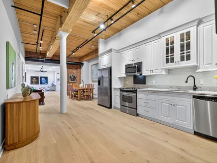 a large kitchen with stainless steel appliances granite countertop a stove and cabinets