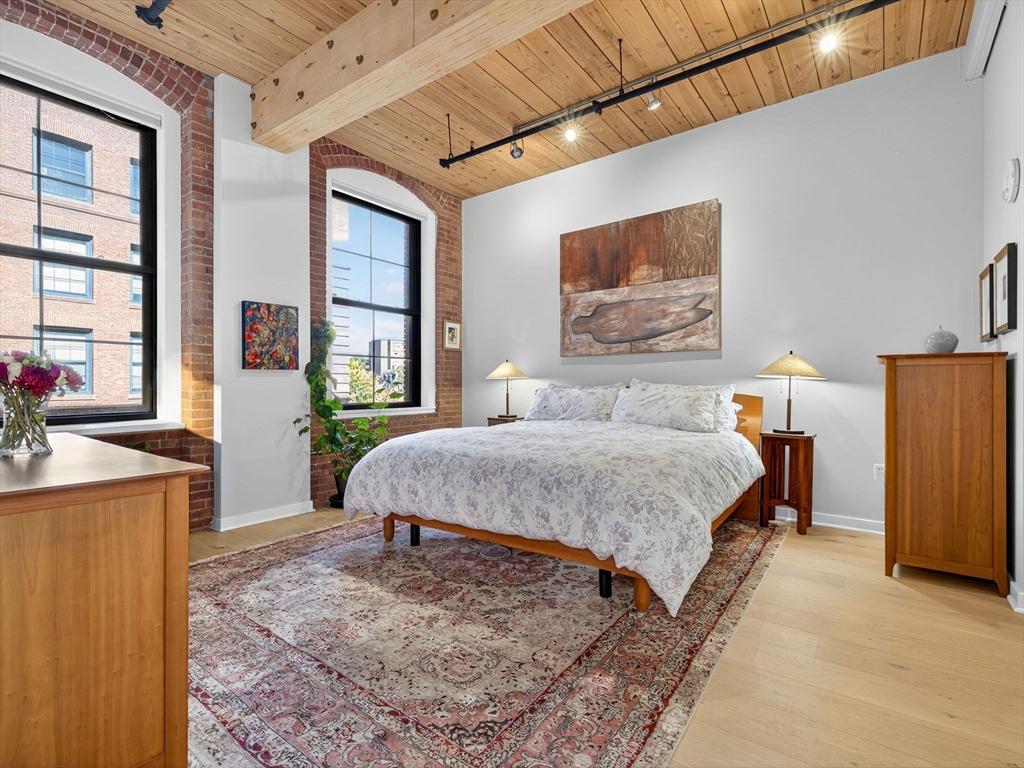 1245 Adams Street, Unit B406 Boston, MA 02124 - Photo 8 of 31 a bedroom with a bed dresser and a window