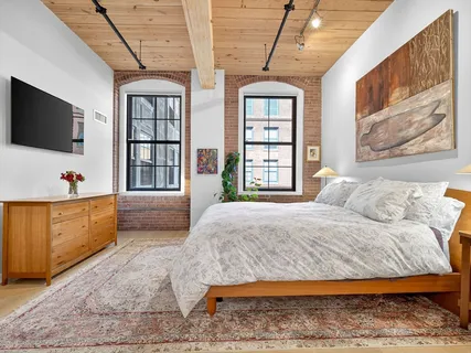 a spacious bedroom with a large bed and a flat screen tv