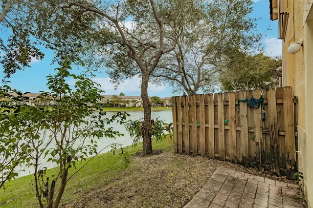 a view of a row of trees with wooden fence
