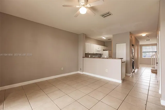 a view of a kitchen with a sink and a refrigerator a kitchen island in the background