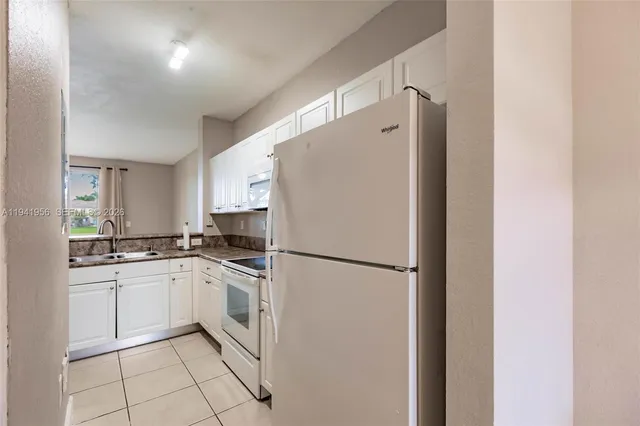 a white refrigerator freezer sitting inside of a kitchen