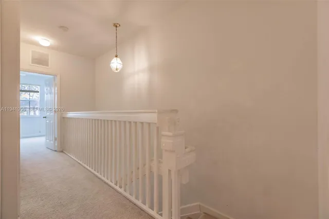 a view of a hallway with chandelier fan