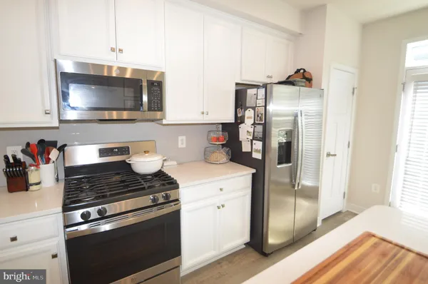 a kitchen with a refrigerator and a stove top oven