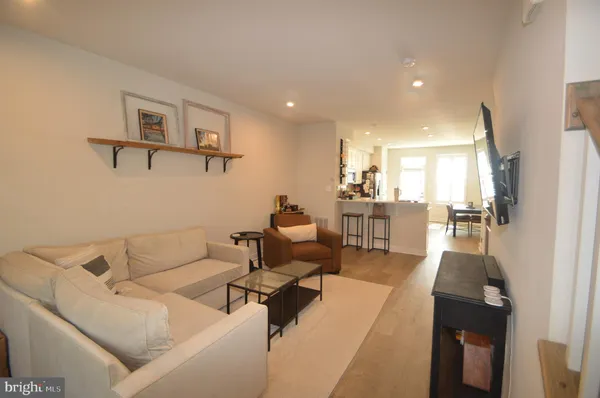 a living room with furniture and a view of kitchen