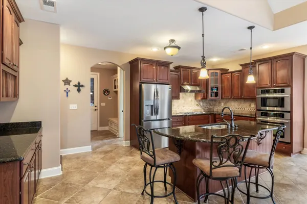 a kitchen with stainless steel appliances granite countertop a sink stove and refrigerator