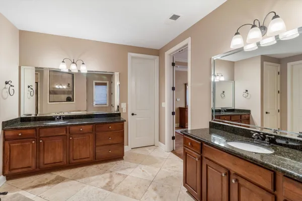 a bathroom with a granite countertop sink toilet a mirror and shower curtain