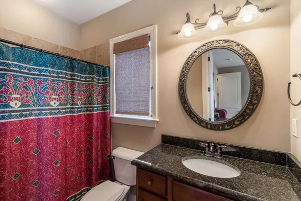 a view of a livingroom with a chandelier fan and wooden floor