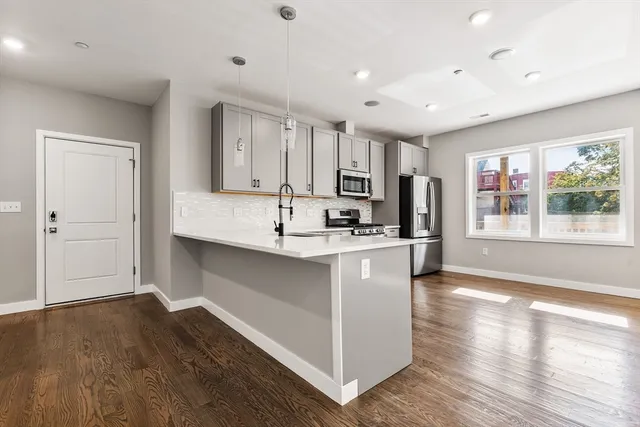 a kitchen with stainless steel appliances granite countertop a sink stove and wooden floor