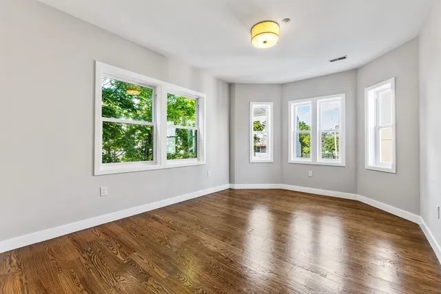 a view of room with window and wooden floor