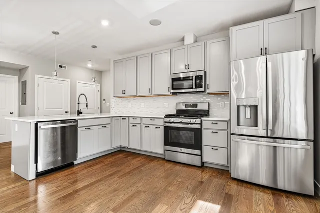 a kitchen with granite countertop white cabinets and stainless steel appliances