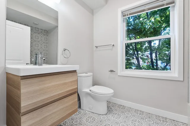 a bathroom with a sink toilet and window
