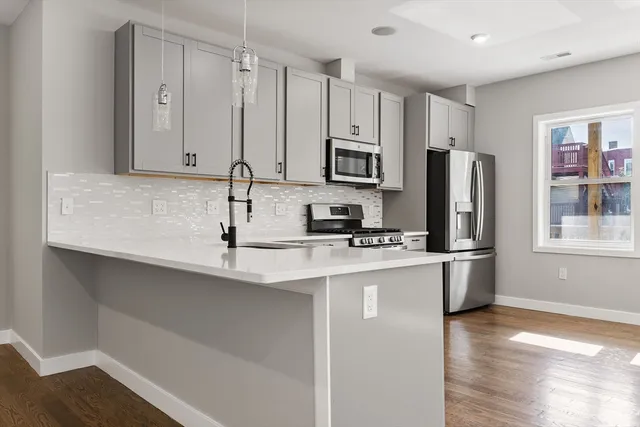 a kitchen with stainless steel appliances a sink stove refrigerator and cabinets