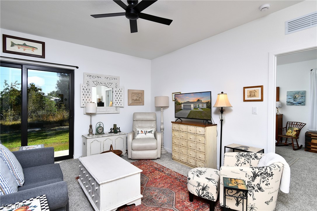 809 Bell Boulevard Lehigh Acres, FL 33974 - Photo 18 of 37 a living room with furniture and a flat screen tv