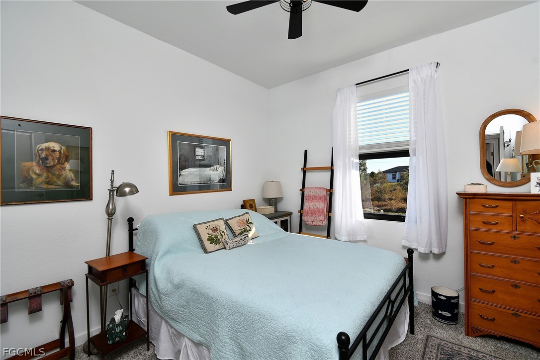 809 Bell Boulevard Lehigh Acres, FL 33974 - Photo 21 of 37 a bedroom with a bed and a dresser