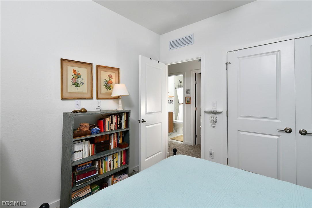 809 Bell Boulevard Lehigh Acres, FL 33974 - Photo 22 of 37 a bedroom with a bed and a book shelf