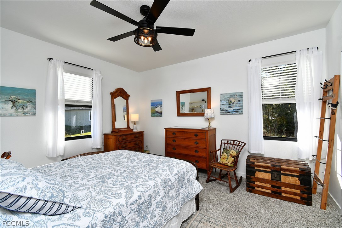 809 Bell Boulevard Lehigh Acres, FL 33974 - Photo 26 of 37 a bedroom with a bed and a dresser next to a window