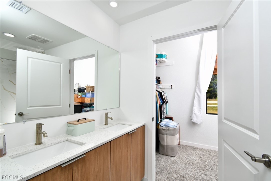 809 Bell Boulevard Lehigh Acres, FL 33974 - Photo 29 of 37 a bathroom with a sink a toilet and a mirror