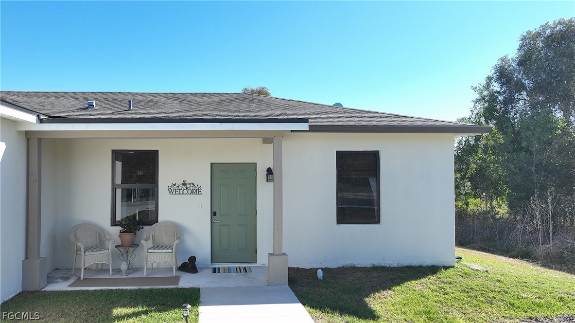809 Bell Boulevard Lehigh Acres, FL 33974 - Photo 8 of 37 a front view of a house with a yard