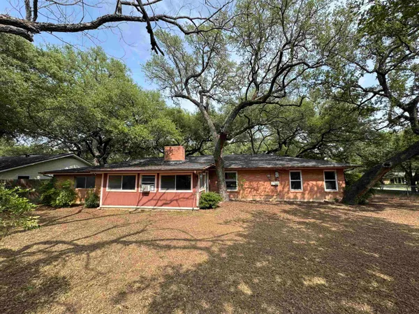 a view of a house with a big yard and large trees