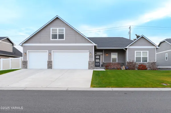 a front view of a house with a garden and yard
